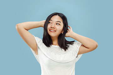 Image showing Korean young woman\'s half-length portrait on blue background