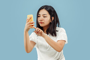 Image showing Korean young woman\'s half-length portrait on blue background