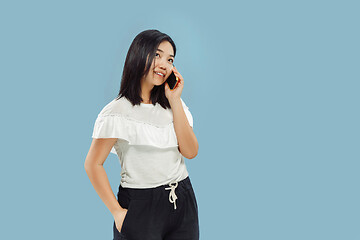 Image showing Korean young woman\'s half-length portrait on blue background