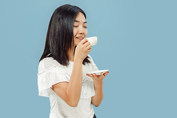 Image showing Korean young woman\'s half-length portrait on blue background