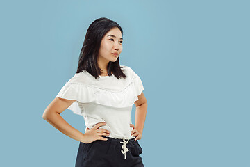 Image showing Korean young woman\'s half-length portrait on blue background