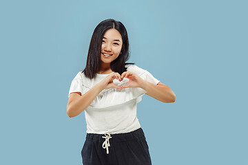 Image showing Korean young woman\'s half-length portrait on blue background