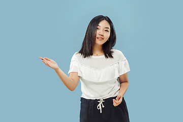 Image showing Korean young woman\'s half-length portrait on blue background