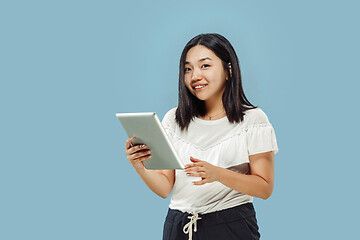 Image showing Korean young woman\'s half-length portrait on blue background