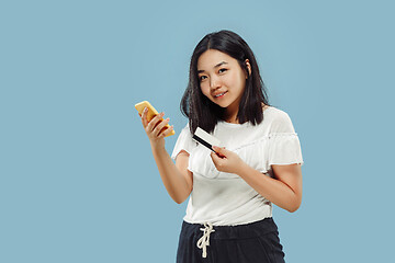 Image showing Korean young woman\'s half-length portrait on blue background