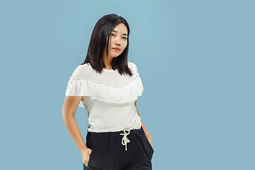 Image showing Korean young woman\'s half-length portrait on blue background