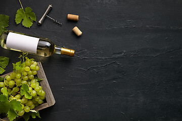 Image showing Top view of tasty fruit plate with the wine bottle on the black stone