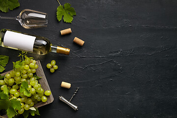 Image showing Top view of tasty fruit plate with the wine bottle on the black stone