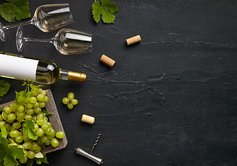 Image showing Top view of tasty fruit plate with the wine bottle on the black stone