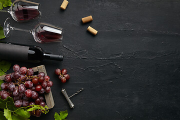 Image showing Top view of tasty fruit plate with the wine bottle on the black stone