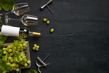 Image showing Top view of tasty fruit plate with the wine bottle on the black stone