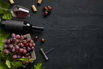 Image showing Top view of tasty fruit plate with the wine bottle on the black stone