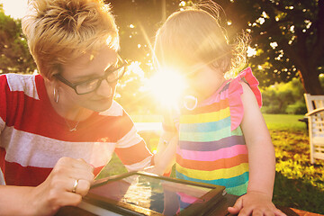 Image showing mom and her little daughter using tablet computer