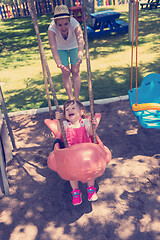 Image showing mother and daughter swinging in the park