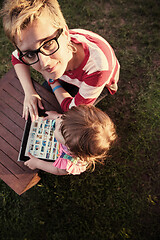 Image showing mom and her little daughter using tablet computer