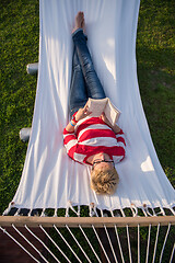 Image showing woman reading a book while relaxing on hammock