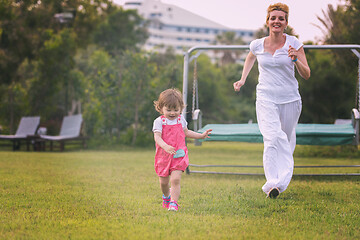 Image showing mother and little daughter playing at backyard