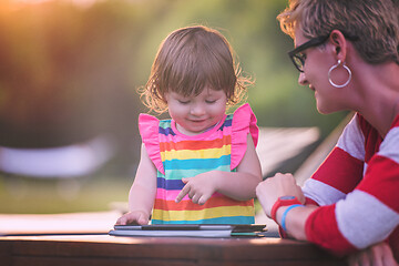 Image showing mom and her little daughter using tablet computer