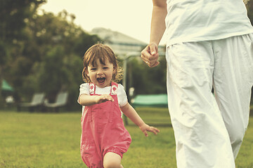 Image showing mother and little daughter playing at backyard