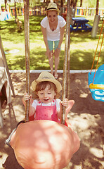 Image showing mother and daughter swinging in the park