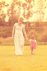 Image showing mother and little daughter playing at backyard