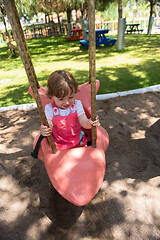 Image showing little girl swinging  on a playground