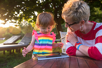 Image showing mom and her little daughter using tablet computer