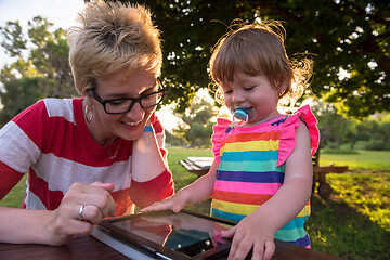 Image showing mom and her little daughter using tablet computer