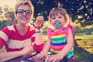 Image showing mom and her little daughter using tablet computer