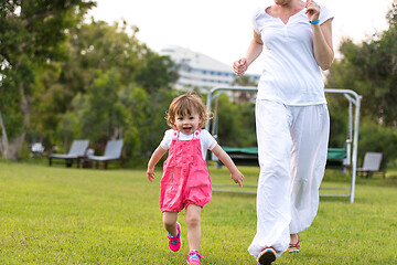 Image showing mother and little daughter playing at backyard