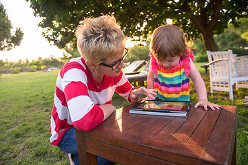 Image showing mom and her little daughter using tablet computer