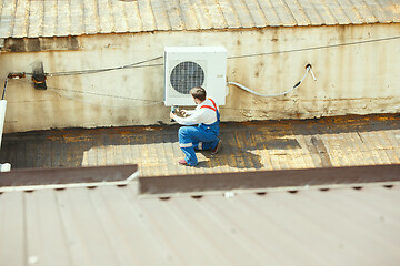 Image showing HVAC technician working on a capacitor part for condensing unit