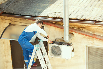 Image showing HVAC technician working on a capacitor part for condensing unit