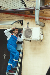 Image showing HVAC technician working on a capacitor part for condensing unit