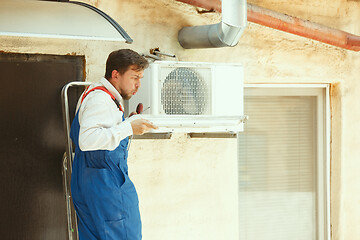 Image showing HVAC technician working on a capacitor part for condensing unit