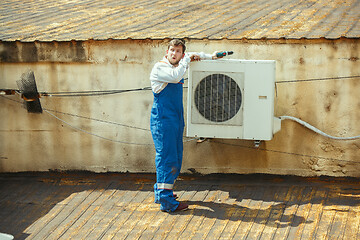 Image showing HVAC technician working on a capacitor part for condensing unit