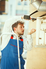 Image showing HVAC technician working on a capacitor part for condensing unit