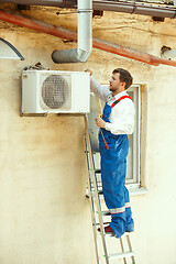 Image showing HVAC technician working on a capacitor part for condensing unit