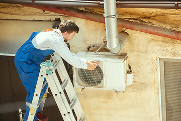 Image showing HVAC technician working on a capacitor part for condensing unit