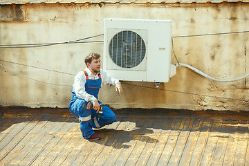 Image showing HVAC technician working on a capacitor part for condensing unit