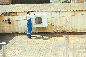 Image showing HVAC technician working on a capacitor part for condensing unit