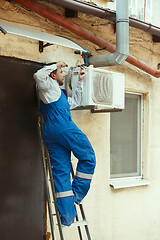 Image showing HVAC technician working on a capacitor part for condensing unit