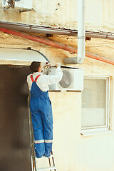 Image showing HVAC technician working on a capacitor part for condensing unit