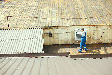 Image showing HVAC technician working on a capacitor part for condensing unit