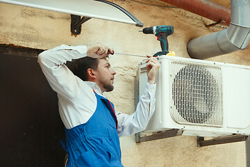 Image showing HVAC technician working on a capacitor part for condensing unit