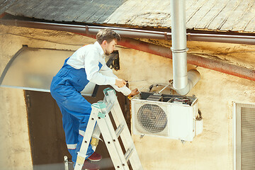 Image showing HVAC technician working on a capacitor part for condensing unit