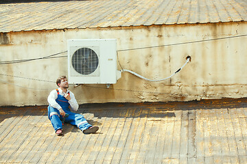 Image showing HVAC technician working on a capacitor part for condensing unit