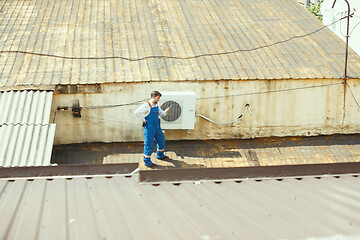 Image showing HVAC technician working on a capacitor part for condensing unit