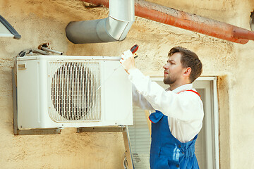 Image showing HVAC technician working on a capacitor part for condensing unit