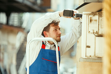 Image showing HVAC technician working on a capacitor part for condensing unit